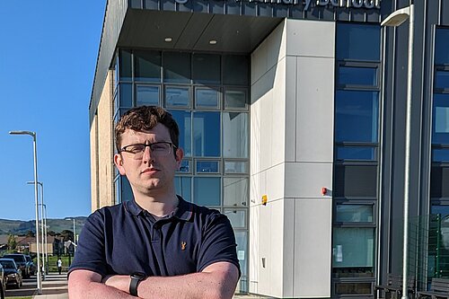 Grant Toghill with his arms crossed outside Dargavel Primary School in Bishopton.