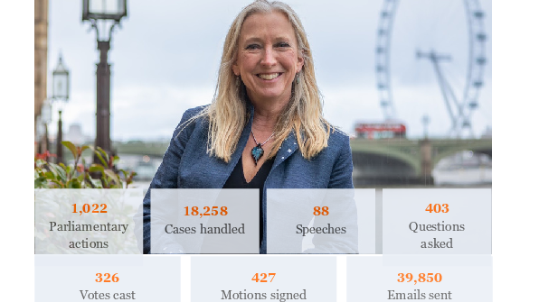 Dr Roz Savage stood up in front of the London Eye which is blurred in the far distance. She is  smiling and wearing a dark blue suit.