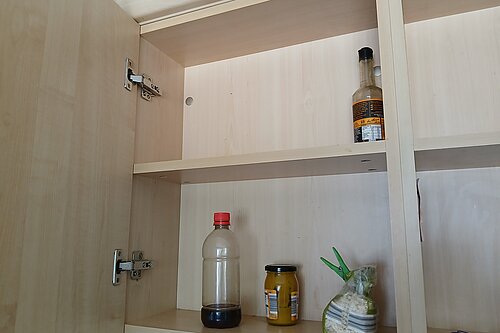 Empty cupboard with just a few half empty jars