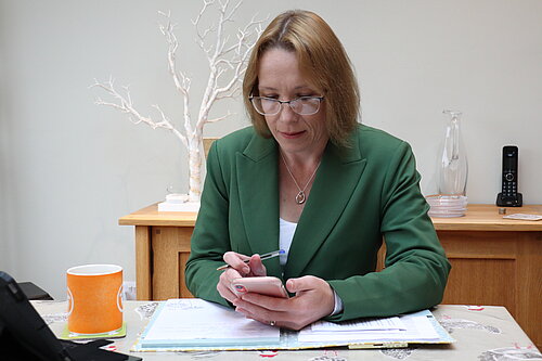 Helen Morgan on her mobile at her desk