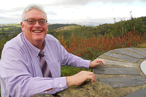 Howard Sykes in front of a view of the countryside in Shaw