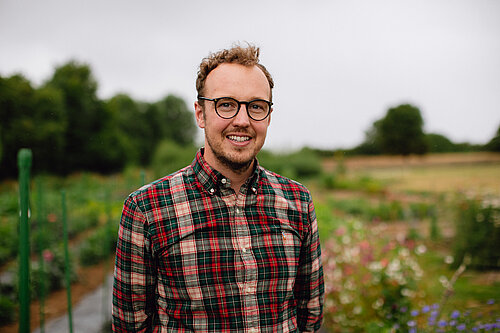 Adam standing in a field